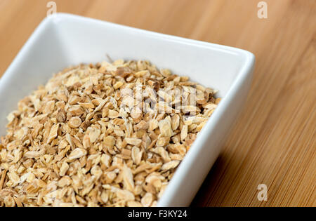 Macro of astragalus root chips against a wooden board Stock Photo