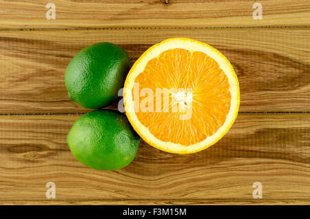 Limes with half orange, overhead Stock Photo