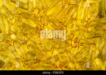 Yellow background texture of omega fatty acid fish oil capsules Stock Photo