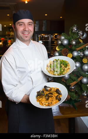 Chef holding Seafood linguine and Orecchiette Pugliese, Strada, Italian chain restaurant, Covent Garden, London, England, UK Stock Photo
