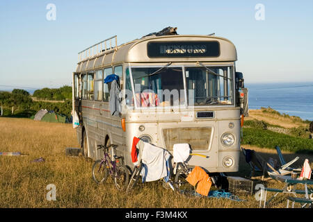 Camping Van (Old bus) on field in South Devon, UK Stock Photo
