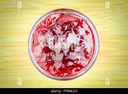 Aerial of a bowl of strawberry jam against a rustic background Stock Photo