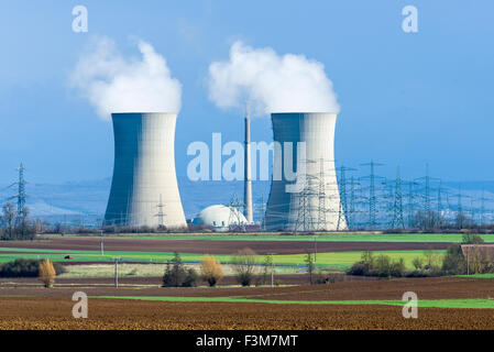 The nuclear powerplant Grafenrheinfeld is steaming out of the cooling towers against dark clouds, located in agricultural landsc Stock Photo