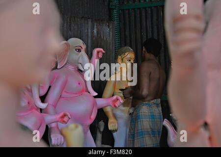 An Artist is busy with decorating the eyes of the clay idol of Goddess Durga for the upcoming Durga Puja festival in Dhaka, Bangladesh. On October 9, 2015  Bangladeshi people were seen making preparations for the Festival of Durga Puja in Dhaka. The Hindu festival, which celebrates goddess Durga Puja, is annually celebrated in different parts of Bangladesh as well as Indian states. Stock Photo