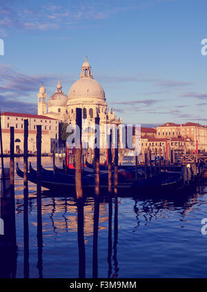 Basilica di Santa Maria della Salute mooring poles and gondolas at sunrise Grand Canal Venice Veneto Italy Europe Stock Photo
