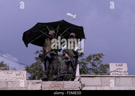 A police surveillance balloon flying over Israeli female soldiers standing on guard in the Muslim Quarter old city Jerusalem Israel Stock Photo