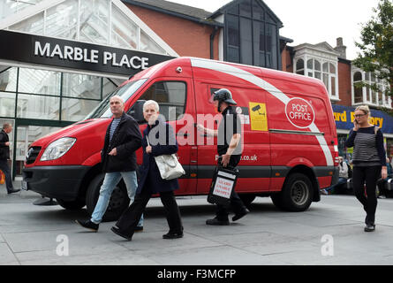 A money cash in transit armored van & guard; Red Post Office vehicle delivering to Primark in Southport, Merseyside, UK. Stock Photo