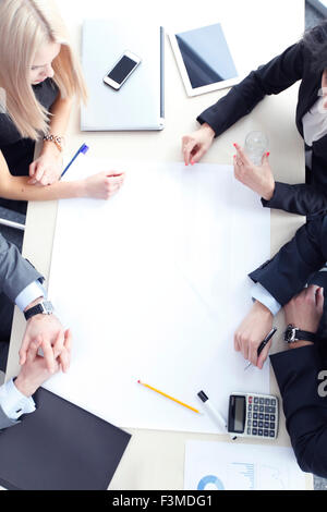 Business people sitting at table with electronic devices on meeting Stock Photo