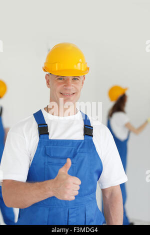 Manual worker with thumb up sign, Indoors Stock Photo