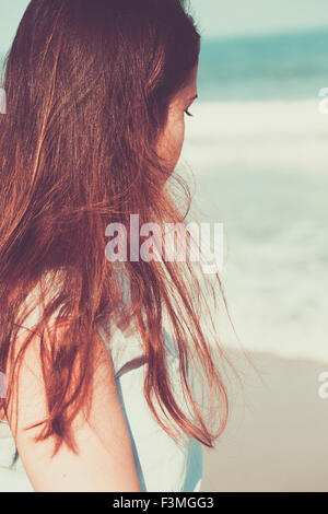 Historical young woman on the beach wearing a blue dress