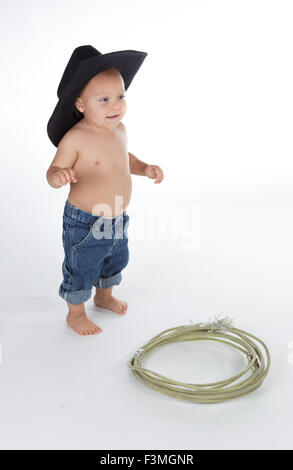 Baby boy dressed as cowboy posing in studio. Stock Photo