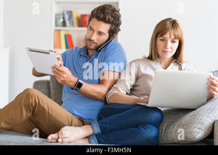 Digital geek couple. Mobile phone, smartwatch, tablet. Modern white apartment Stock Photo