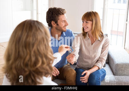 Real estate agent giving house keys to new owners Stock Photo