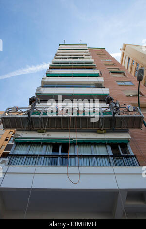Workers over elevator for painting high buildings walls Stock Photo