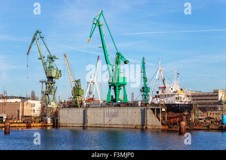 A view of a large ship under repair in dry dock at a shipyard. Stock Photo