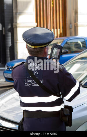 A Traffic Warden issuing a ticket in Liverpool City Centre, Liverpool, UK. Stock Photo