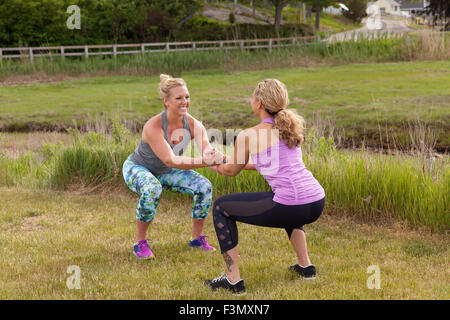 Partner workouts doing squats Stock Photo