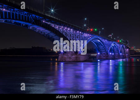 The Peach Bridge linking Canada to the US at Fort Erie, illuminated in purple. Stock Photo