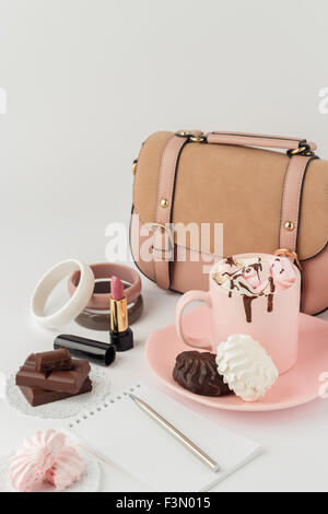 Hot chocolate with marshmallows and women's  fashion accessories on a white background. Selective focus. Stock Photo