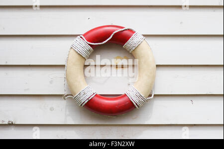 Decorative life preserver on rustic weather board wall, hanging on the side of a beach house Stock Photo