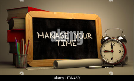 Handwritten Manage Your Time on a Chalkboard. Stock Photo