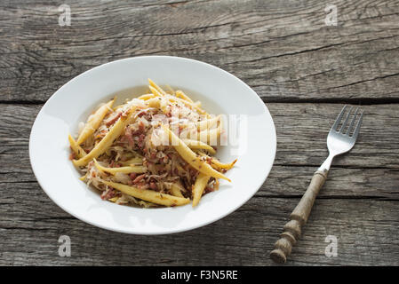 Finger shaped potato dumplings with sauerkraut and ham Stock Photo