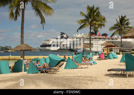 people on a beach with cruise ships and palm trees in the background Stock Photo