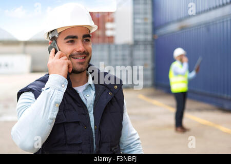 View of a Young Attractive docker using mobile phone at work Stock Photo