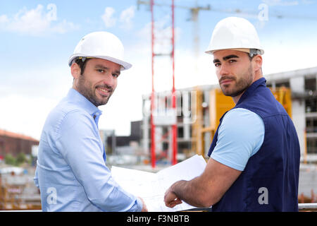 View of an Engineer and worker checking plan on construction site Stock ...