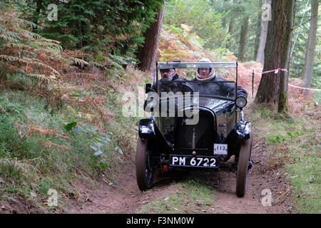 New Radnor, Powys, Wales - Saturday 10th October 2015 - The Vintage Sports Car Club ( VSCC ) hill climb trial challenge on The Smatcher a steep wooded hill just outside New Radnor. Competitors score points the further they drive up the steep hill with 25 points being awarded for reaching the top. The passenger acts as 'bouncer' who bounces to help the car grip on the steep sections. Shown here is a 1926 Austin 7 Chummy. Stock Photo