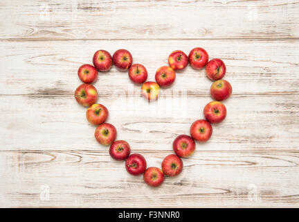 Red apples heart over rustic wooden background. Love concept Stock Photo