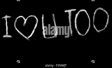 'I LOVE U TOO' with abstract heart, handwritten with white chalk on a plain black background. Stock Photo