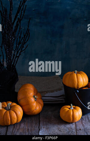 Little pumpkins on Halloween decorated table with spiders and bat