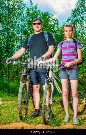 portrait of a couple of athletes with bicycles on a sunny day Stock Photo