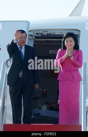 Phnom Penh, Cambodia. 11th Oct, 2015. Cambodian Prime Minister Hun Sen (L) and his wife Bun Rany gesture from the plane before their departure in Phnom Penh, capital of Cambodia, Oct. 11, 2015. Hun Sen left Phnom Penh on Sunday for a series of international meetings in China's Macao and Beijing to be held from Oct. 12 to 17, a senior official said. Credit:  Sovannara/Xinhua/Alamy Live News Stock Photo