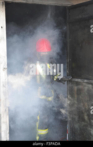 Firefighters with protective equipment in a smoke filled room