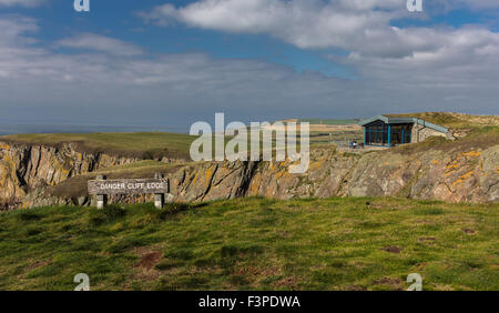 Looking past Danger Cliff Edge sign to the Gallie Craig cafe at the Mull of Galloway in Dumfries and Galloway, Scotland. Stock Photo