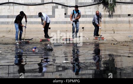 (151011)-- DAMASCUS, Oct. 11, 2015(Xinhua)-- Young Syrians clean an aqueduct connecting Barada River in Damascus, capital of Syria, on October 11, 2015. Around 100 young Syrians on Sunday participated in a campaign to clean the aqueduct. Since the upstream of Barada River has been controlled by opposition militants in the past years, the water supply via the aqueduct to Damascus decreased while trashes appeared more in the aqueduct, defacing the city of Damascus. (Xinhua/Zhang Naijie)(azp) Stock Photo