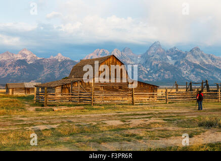 Female photographer capturing historic John Moulton Homestead (c 1910), Mormon Row Historic District, Grand Teton National Park Stock Photo