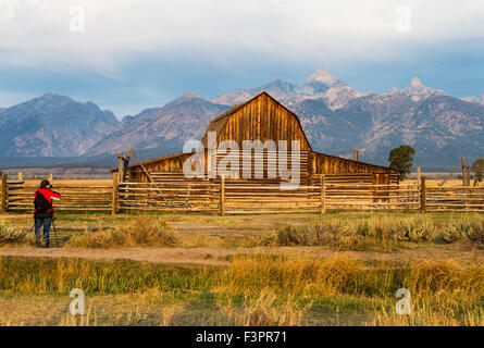 Female photographer capturing historic John Moulton Homestead (c 1910), Mormon Row Historic District, Grand Teton National Park Stock Photo