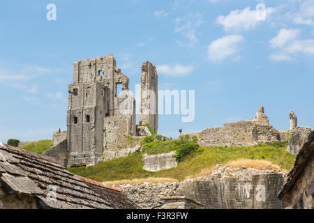 Iconic ruins of hilltop medieval Corfe Castle, a popular leading sightseeing landmark in Wessex, Dorset, southwest England with blue sky on sunny day