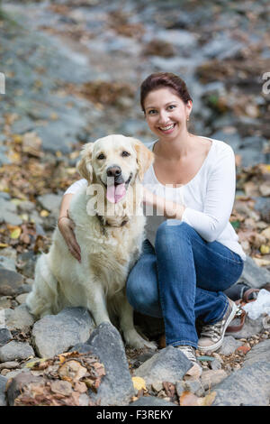 Woman sitting in the forest with Labrador Stock Photo