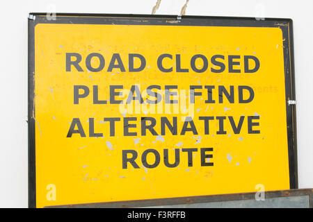 Temporary yellow 'road closed please find alternative route' sign. Stock Photo