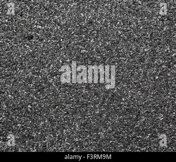 Abstract dark granular background. Close-up abrasive texture roofing material. Stock Photo