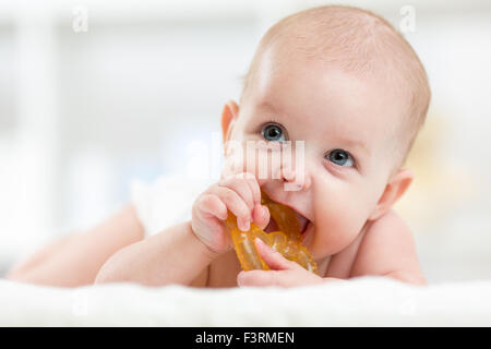 baby child lying on belly weared diaper with teether Stock Photo