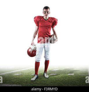 Composite image of a serious american football player taking his helmet on her hand looking at camer Stock Photo