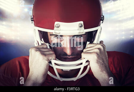 Composite image of portrait of rugby player wit hands on helmet Stock Photo