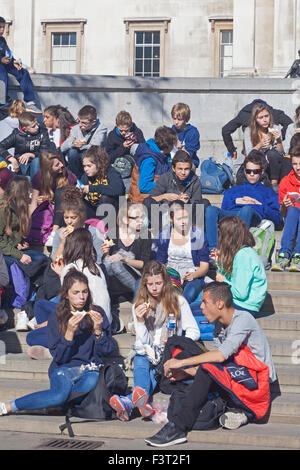 London, Trafalgar  Square  A school party of Continental students stopping for lunch Stock Photo