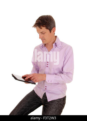 A young businessman sitting isolated for white background and working on his tablet pc. Stock Photo