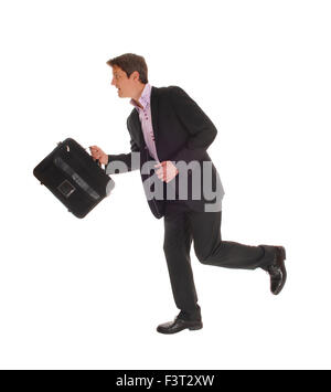 A running businessman in a dark suit and a briefcase in his hand, isolated for white background. Stock Photo